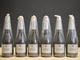 six bouteilles de vin sont alignées sur une table