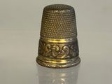 a silver thimble sitting on top of a glass table