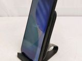 a close up of a cell phone on a stand on a white surface