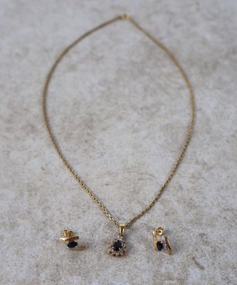 un ensemble composé d'un collier et de boucles d'oreilles en or, serti d'un diamant noir