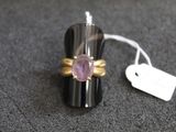 une bague ornée d'une pierre rose et d'une étiquette de prix