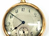 a close up of a pocket watch on a white surface