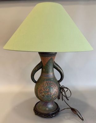 une lampe surmontée d'un abat-jour vert