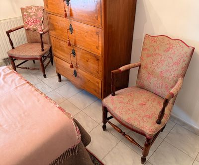 deux chaises et une commode dans une pièce