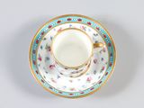 a tea cup and saucer on a white table