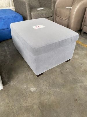 1 POUF sur pied en tisssu gris.