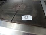 une photo d'une plaque de cuisson en acier inoxydable sur laquelle est apposée une étiquette de prix