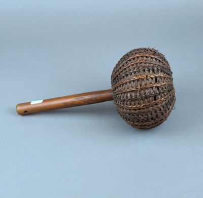 une petite pipe avec un manche en bois posée sur une surface grise