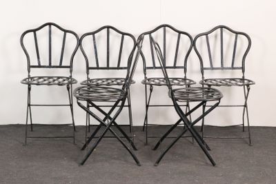 four black metal folding chairs sitting next to each other in a room