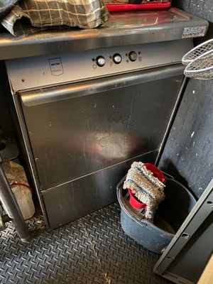 an image of a dirty kitchen with a dishwasher and a trash can