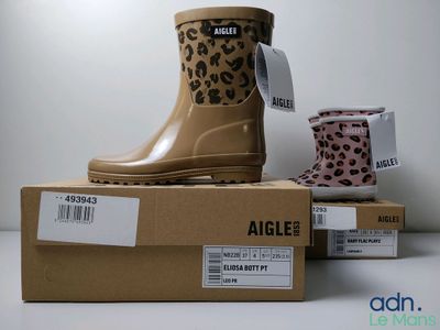 trois paires de bottes de pluie sont posées sur une boîte
