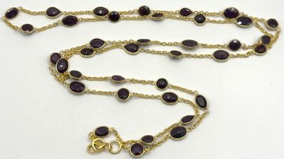 collier composé de perles de verre violettes et d'une chaîne plaquée or