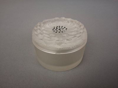 a white container with a flower on it on a table