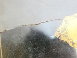 a broken mirror with a picture of a coat of arms on it