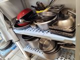 many pots and pans on the shelves in the kitchen