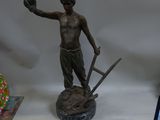 a statue of a man holding a baseball glove and a ball