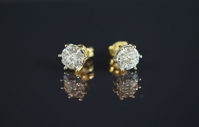 une paire de boucles d'oreilles en diamant posées sur une surface noire