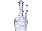 une image représentant une bouteille en verre transparent munie d'une anse, sur fond blanc