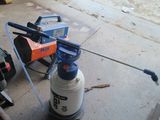 a blue and white sprayer sitting on the ground next to a motorcycle