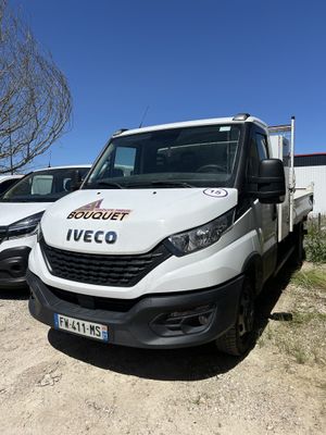 une camionnette blanche garée à côté d'autres voitures