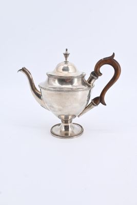 une théière ancienne en argent avec une anse en bois, sur fond blanc