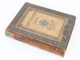 an old book sitting on top of a table on a white surface