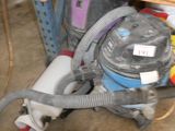 a vacuum that is sitting under a table in a room