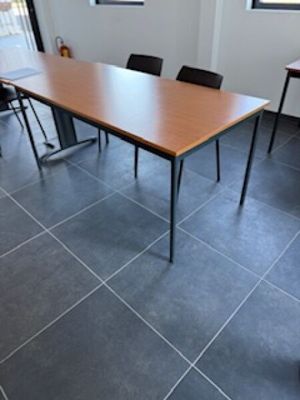 des tables et des chaises dans une pièce avec un sol carrelé et des fenêtres