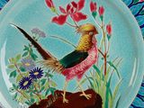 a colorful plate with a bird and flowers on it