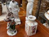 two figurines sitting on a table in front of a glass case