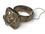 une bague en argent ornée d'un nœud, posée sur un fond blanc