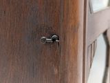 close up of a wooden cabinet with a glass door and metal handles
