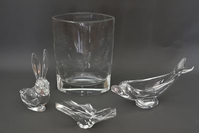trois oiseaux en verre posés sur une table, à côté d'un vase en verre