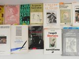 beaucoup de livres accrochés au mur, avec une paire de ciseaux