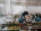 de nombreux vases de toutes sortes posés sur une étagère en verre dans une pièce