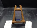 un téléphone portable posé sur un support en bois à côté d'une boîte de mouchoirs