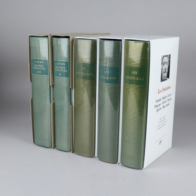 four books in a row sitting on top of a white table