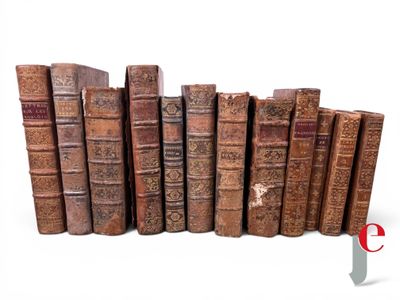 several old books are lined up in a row on a white surface