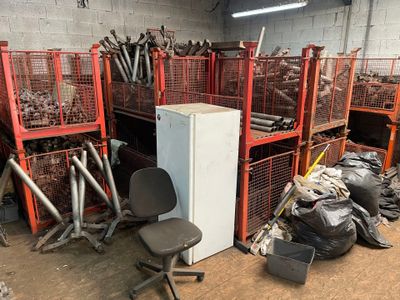 a room with a refrigerator, chair, and other items in it