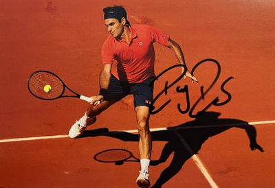 photo dédicacée d'un joueur de tennis sur un court en terre battue, une raquette à la main