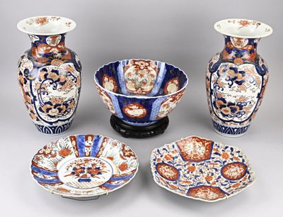 trois vases, un bol et une assiette sont posés sur une table