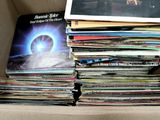 une boîte en carton remplie d'une multitude de disques vinyles