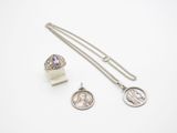 a couple of silver necklaces and a coin on a white surface