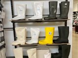 many pairs of rain boots on the shelves in the store