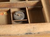 an old wooden box with a small clock inside of it
