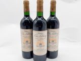 trois bouteilles de vin rouge posées sur une table blanche