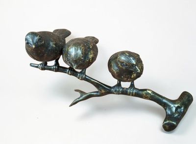 three birds perched on a branch of a tree