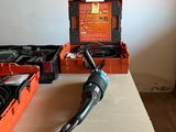 a drill on a table next to a box of tools