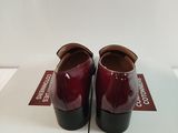 two pairs of red shoes sitting on top of a white box