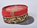 a red hat with gold trim on top of a coin